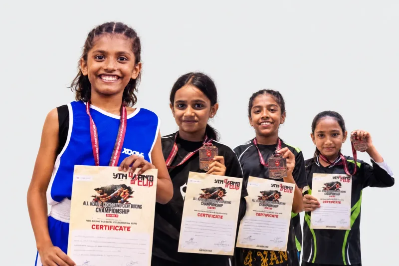 Edited collage of four Apex kick boxing medal winners holding their medals and certificates