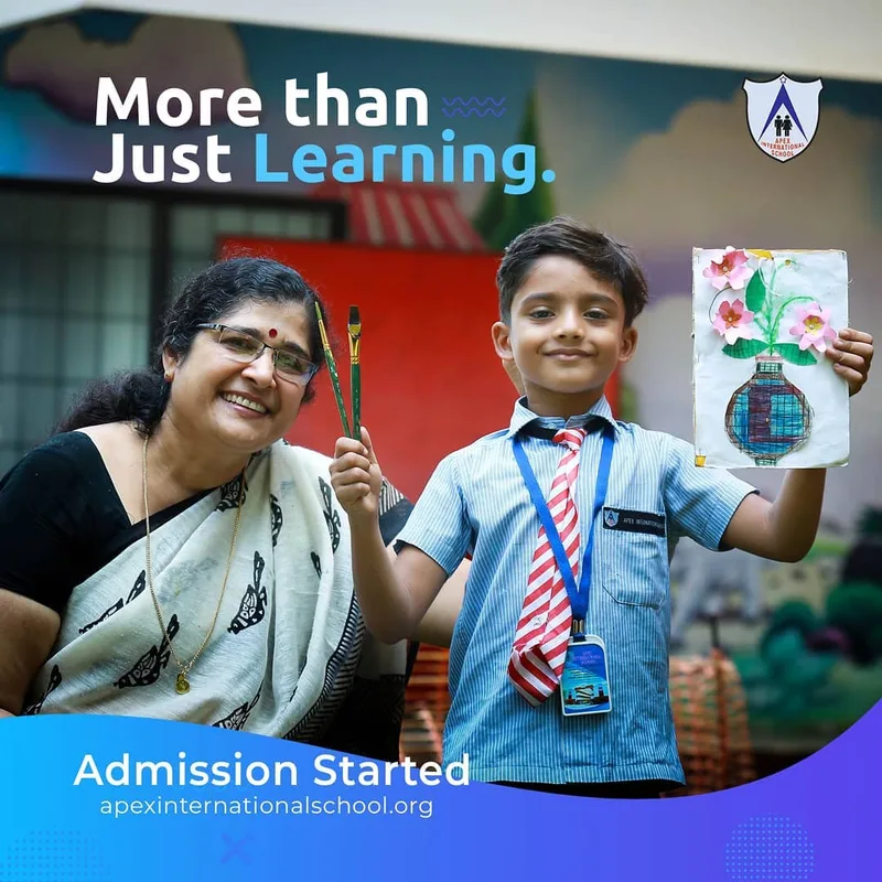 A teacher and pupil holding a handmade flower picture in a 2019 school post